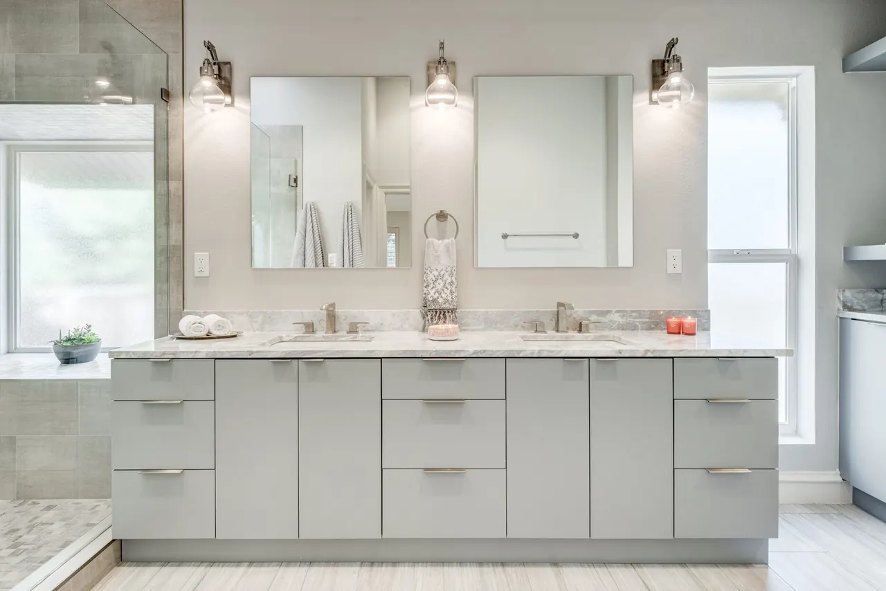 Allen bathroom remodel idea: gray double vanity with marble counters, framed mirrors and sconces