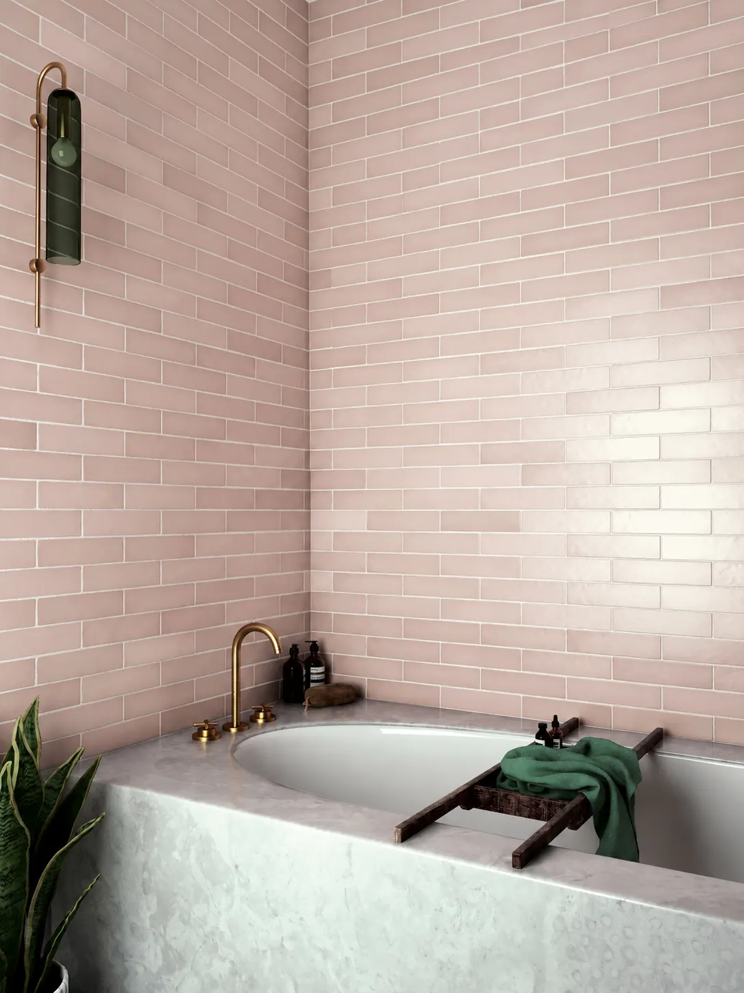 Guest bathroom soaking tub with a marble surround, blush pink tile and a brass wall faucet