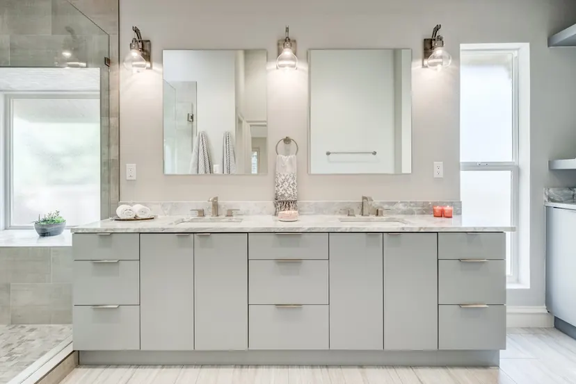 Wylie bathroom remodel idea: gray double vanity with marble counters, framed mirrors and sconces